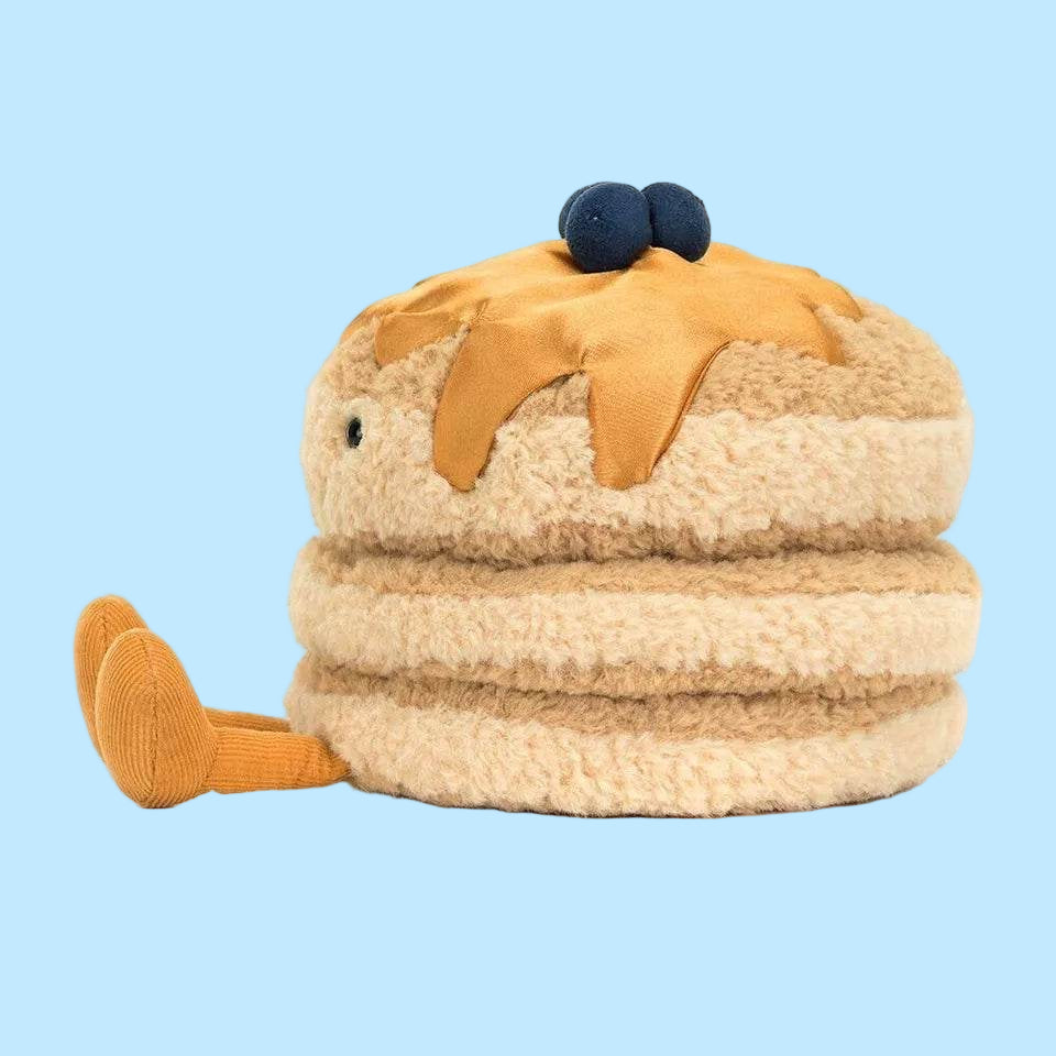 Plush toy resembling a cake with blueberries on top against a white background