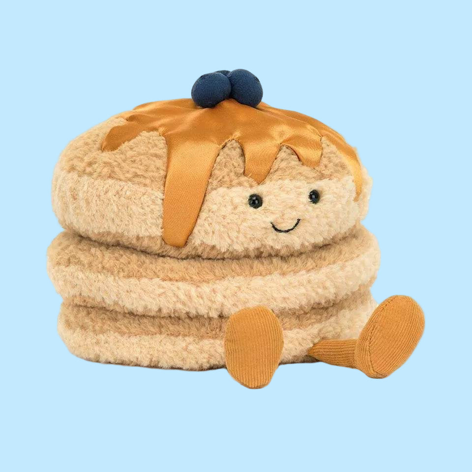 Stuffed toy resembling a pie with a smiling face on a white background